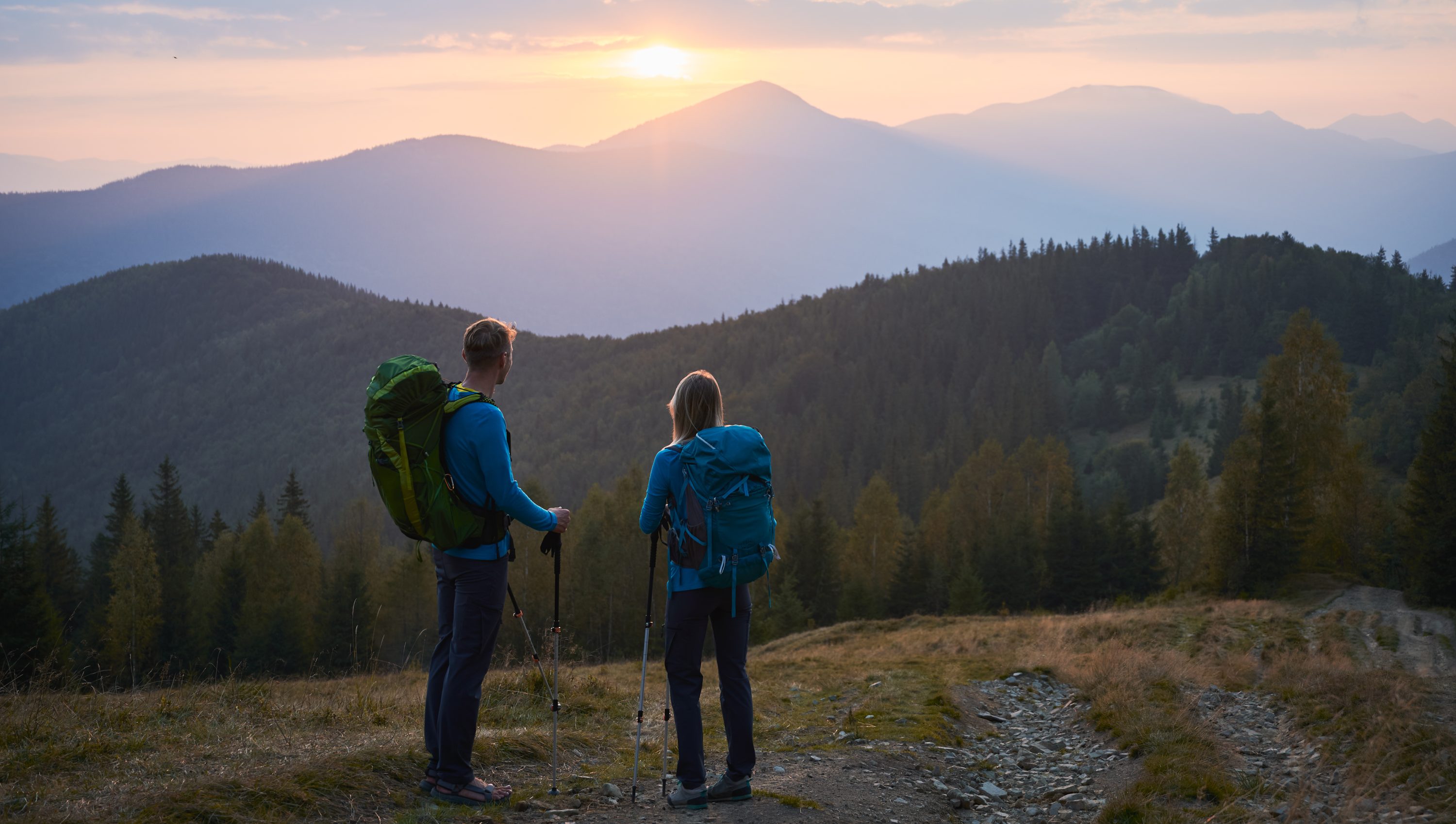 Hiking in the mountains at sunset in summer.