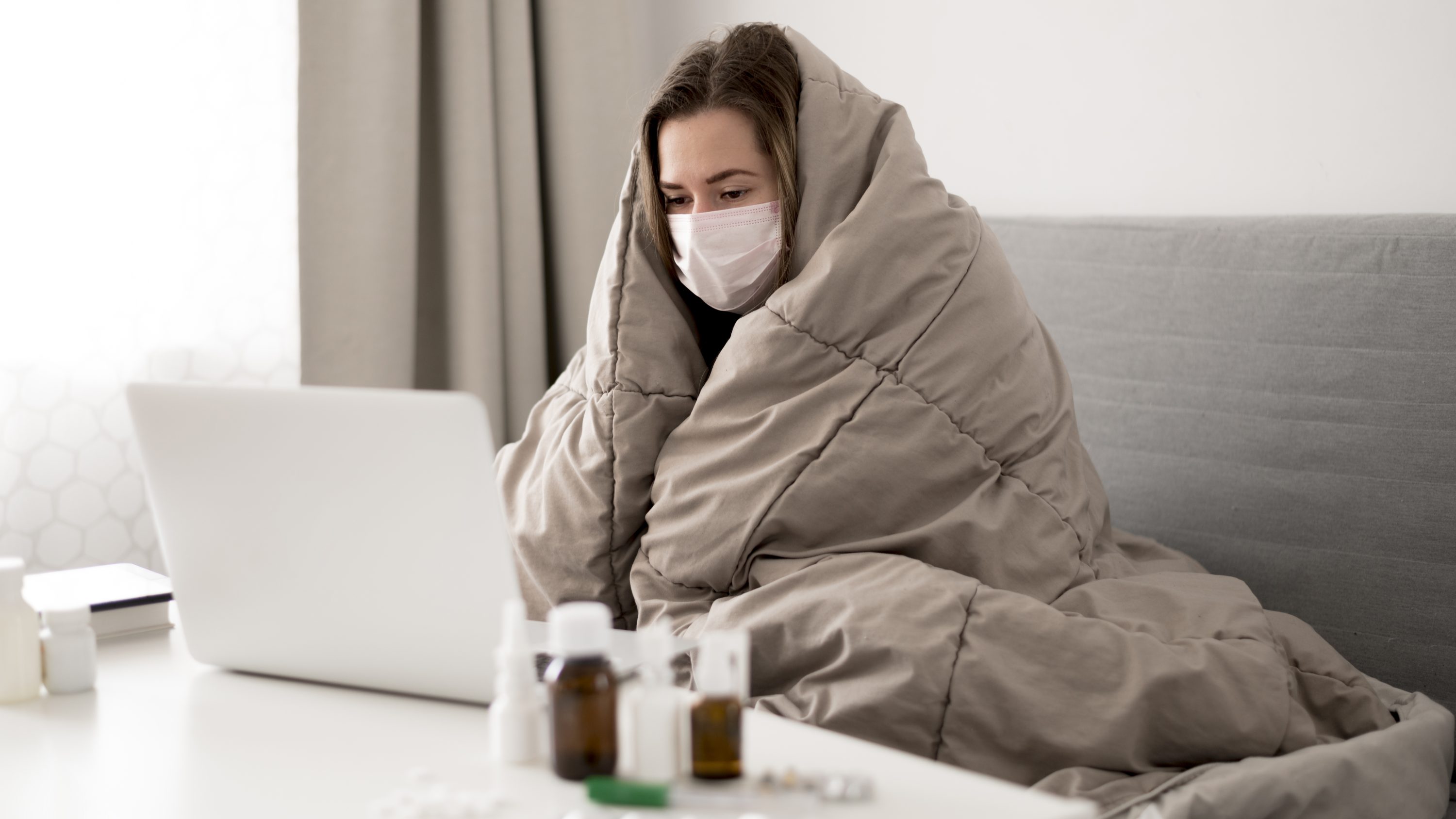 woman-wearing-medical-mask-wrapped-blanket