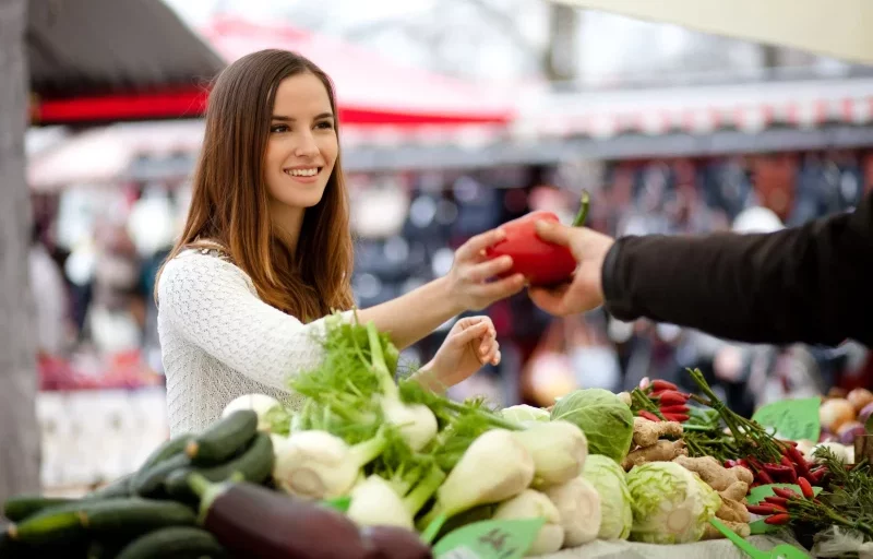 Девушка выбирает фрукты на рынке