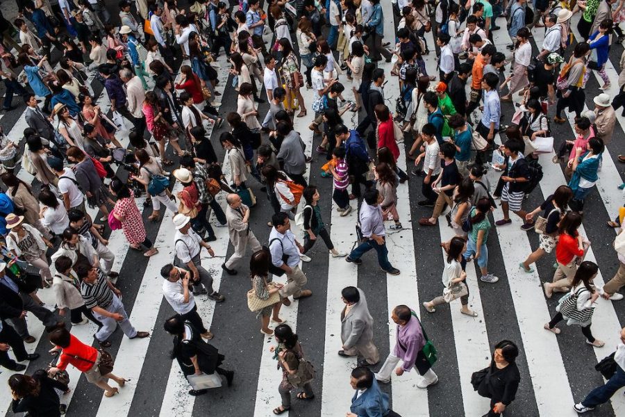 люди идут по городу население много людей