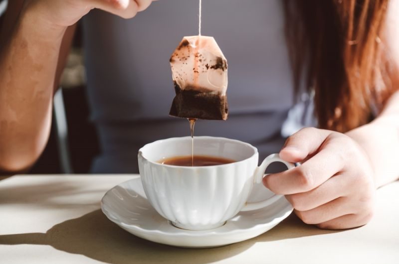 Чайный пакетик девушка пьет чай заварка пакетированного чая